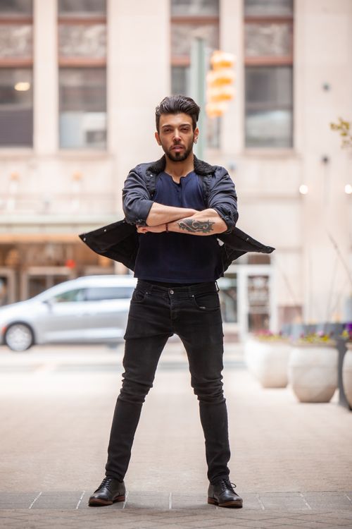 Free Confident man with tattoo posing with arms crossed in city setting. Stock Photo