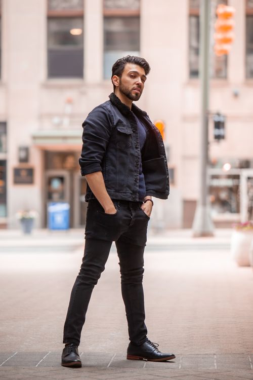 Free Confident man in black denim jacket and pants posing in urban setting, hands in pockets. Stock Photo