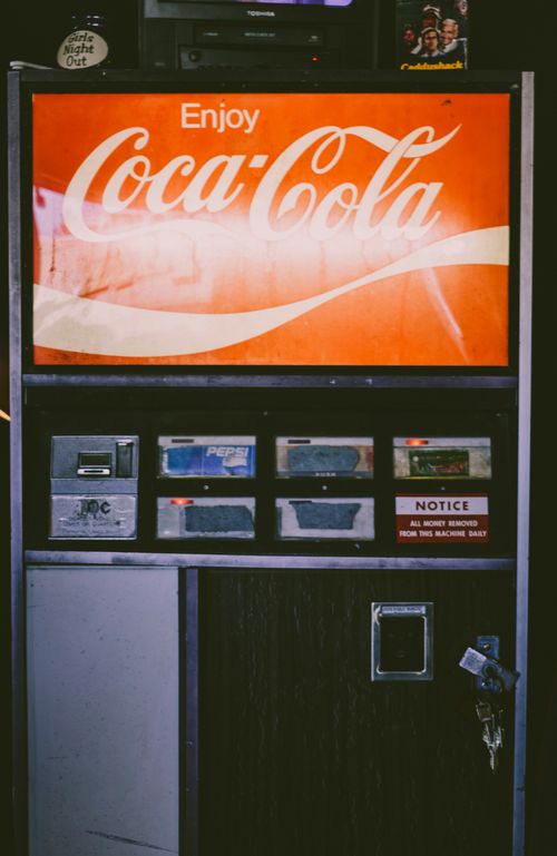 Free Old-fashioned Coca-Cola vending machine captured indoors with retro style. Stock Photo
