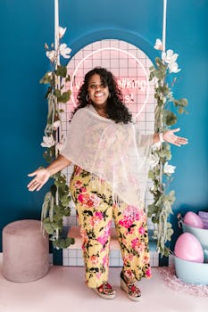 Fashionable woman in floral outfit smiling indoors in a vibrant setting.