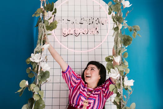 Asian woman smiling on a decorated swing indoors with colorful background.