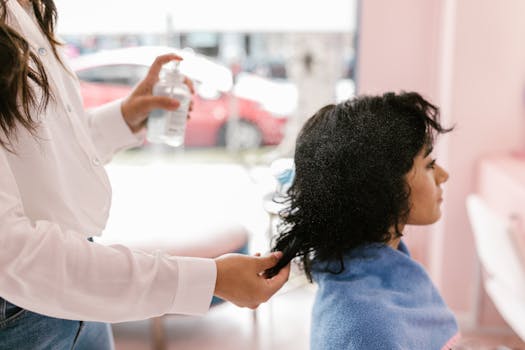 A woman getting her hair styled at a salon, focusing on self-care and pampering.