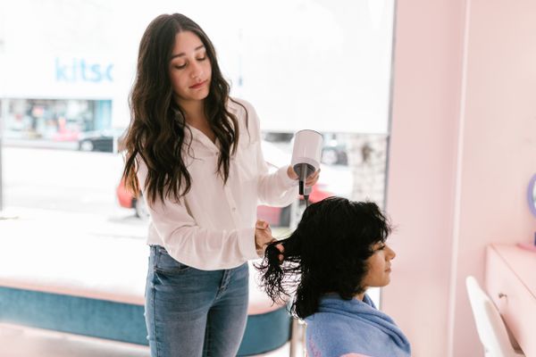 Colourist working precisely on a client's hair in the studio
