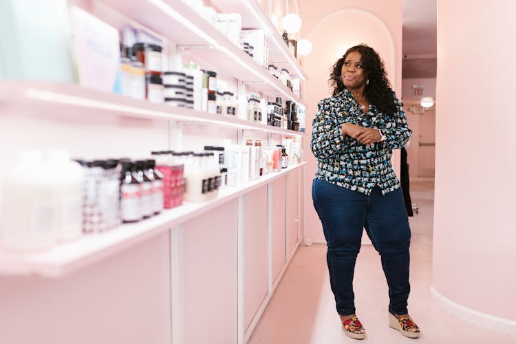 A Woman Looking At Beauty Products On A Shelf