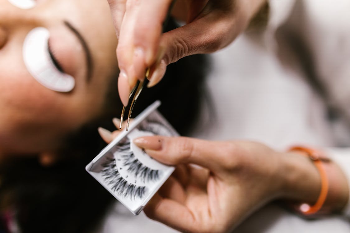 Free Close-Up Shot of a Person Holding a Tweezer and False Eyelashes Stock Photo