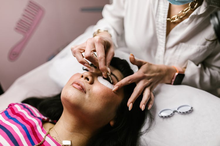 A Woman Putting On Eye Lashes