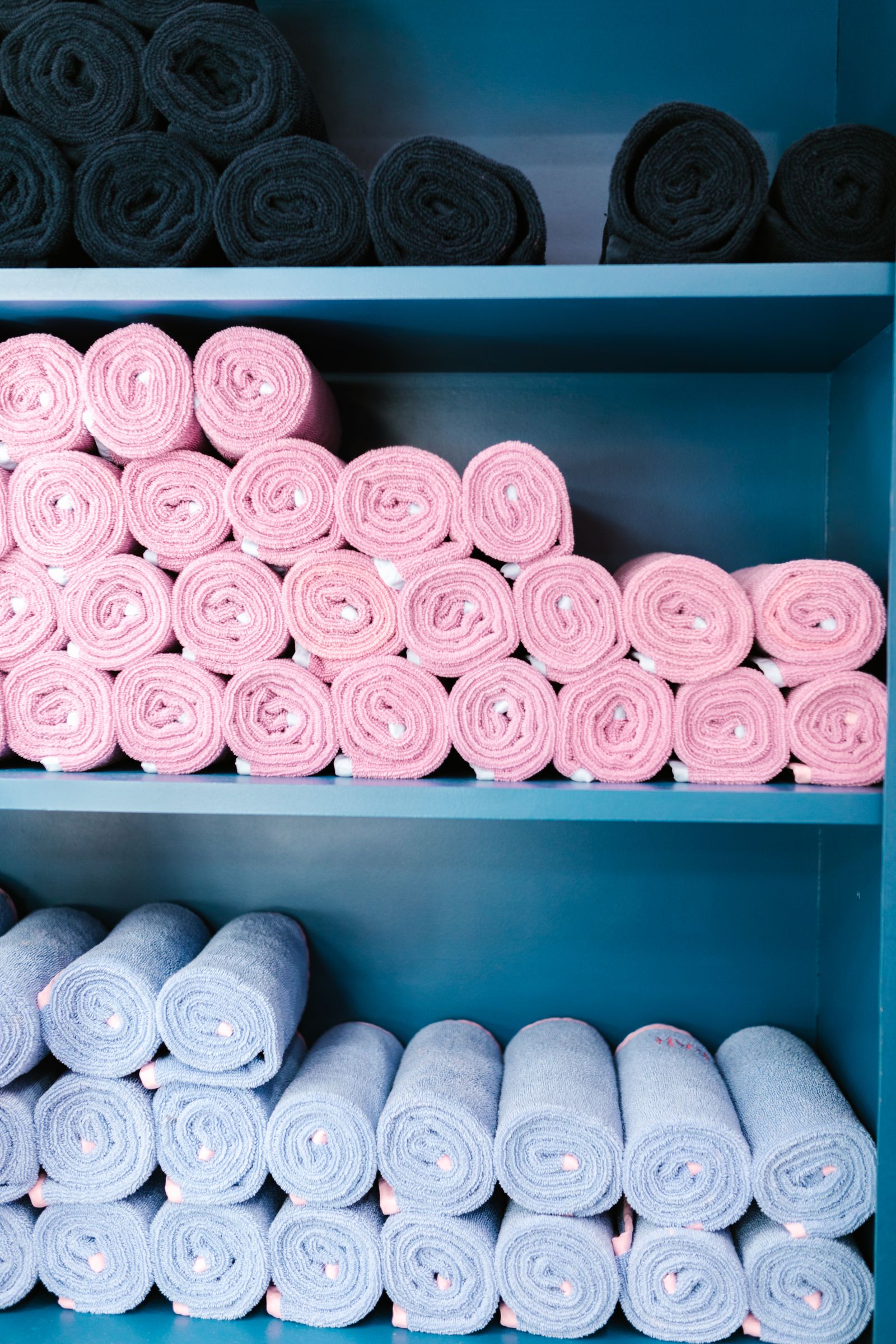 A colourful range of rolled kitchen towels arranged together on shelving, showing the variety available in a multipack