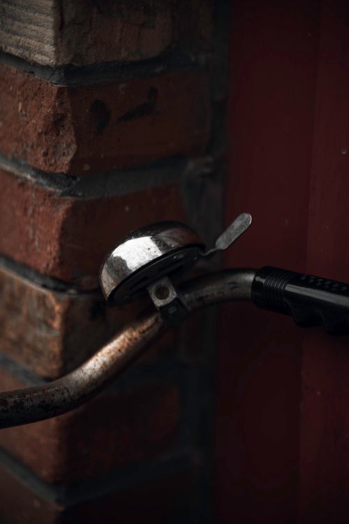 Free Close-up of a rusty bike bell on handlebars against a brick wall. Stock Photo