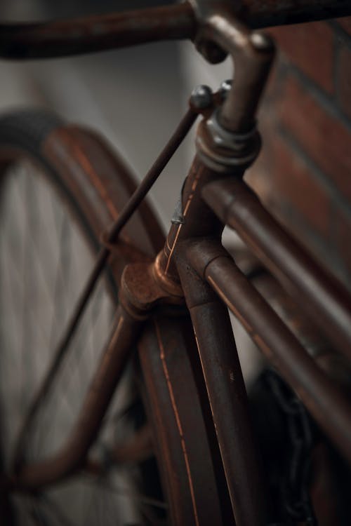 Rusty Bicycle Beside Brown Brick Wall
