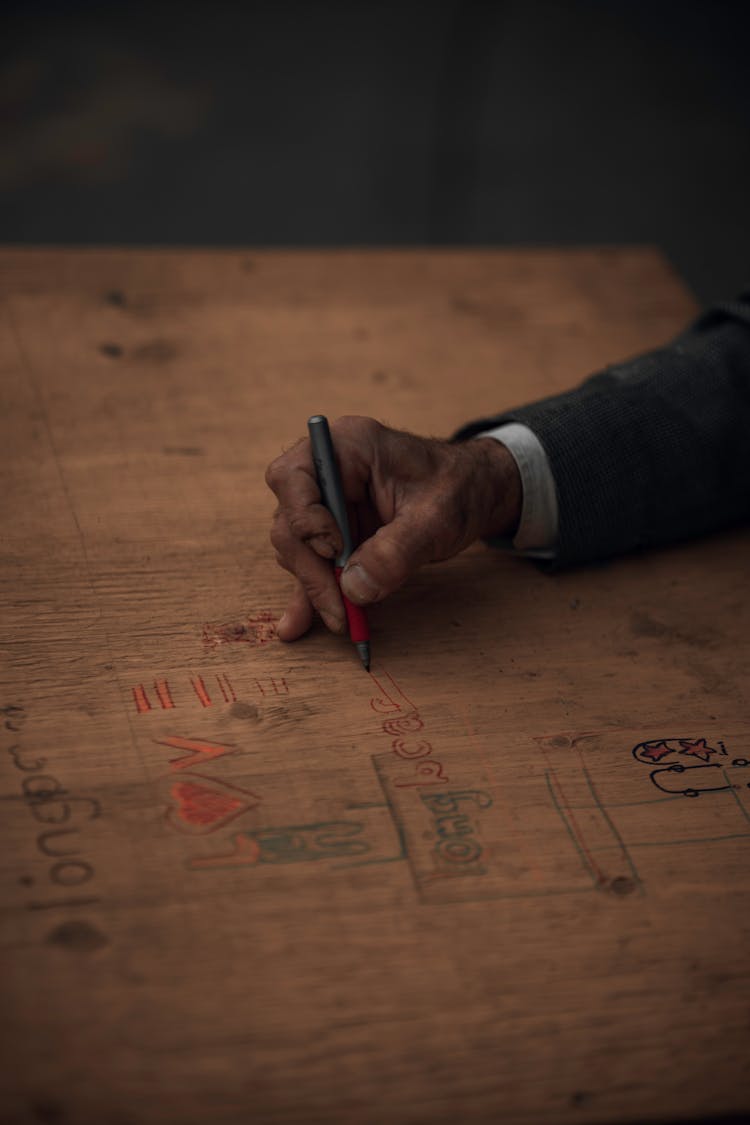 Elderly Person Drawing On A Wood Board