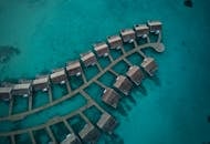 热带度假胜地的碧绿海水中，水上平房的空中拍摄令人惊叹