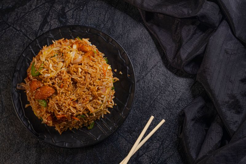 Nasi goreng di piring hitam (ilustrasi)