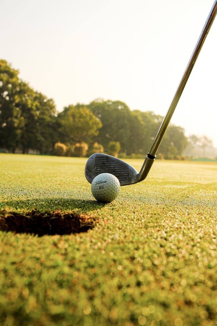 Golf Club Hitting Ball On Field