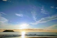 海洋与岛屿的轮廓映衬着五颜六色的天空，呈现出一片宁静的日落景色