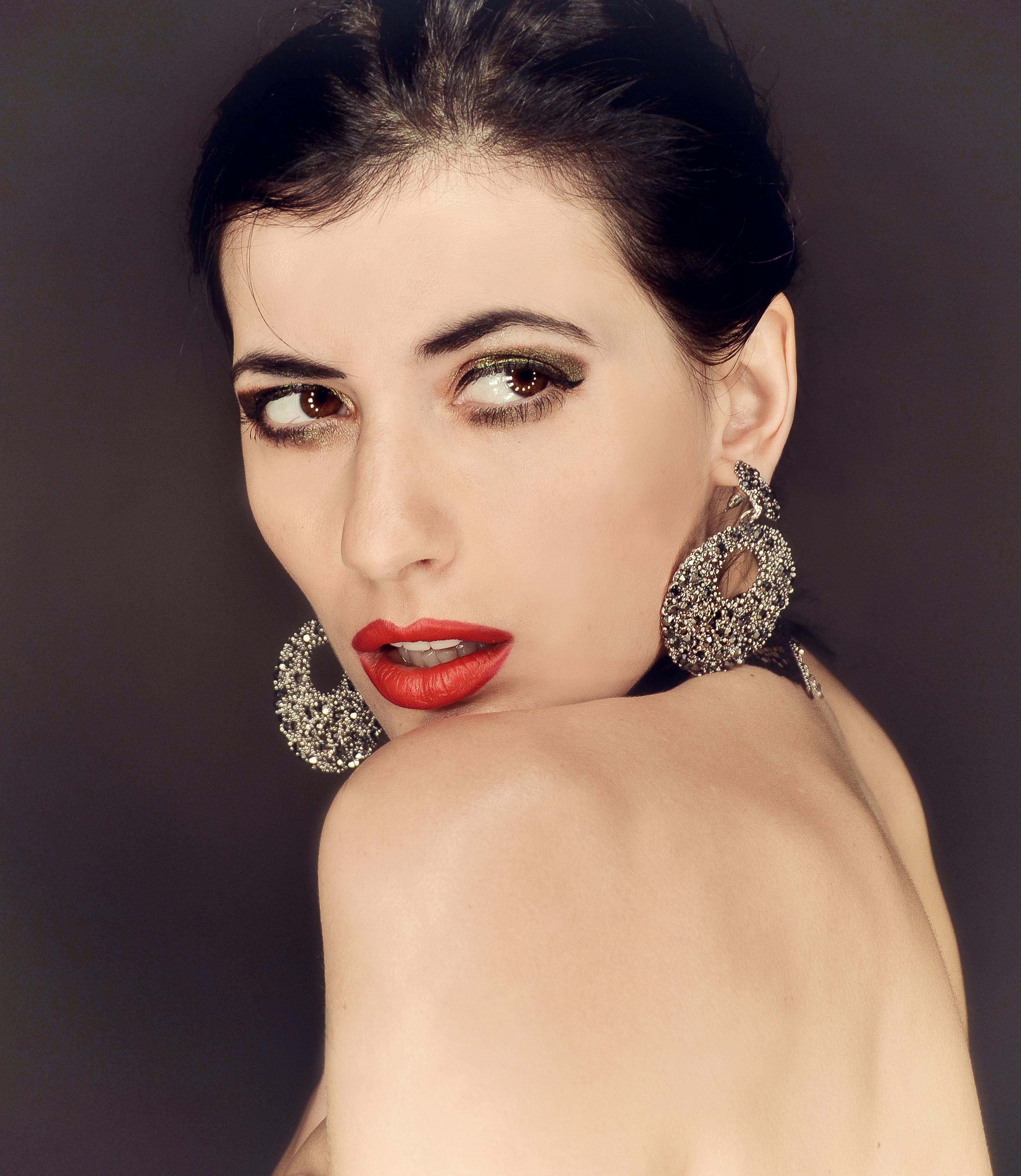 confident female with red lips looking away against gray background