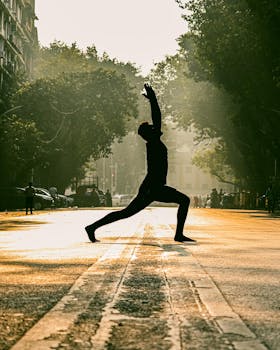 Silhouette of a person practicing yoga on a street in Mumbai at sunrise, creating a serene and vibrant scene.