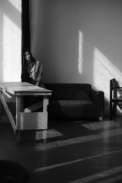 Grayscale Photo of Woman Sitting on Couch