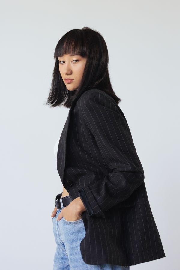 woman wearing pinstripe blazer and dark jeans smart casual
