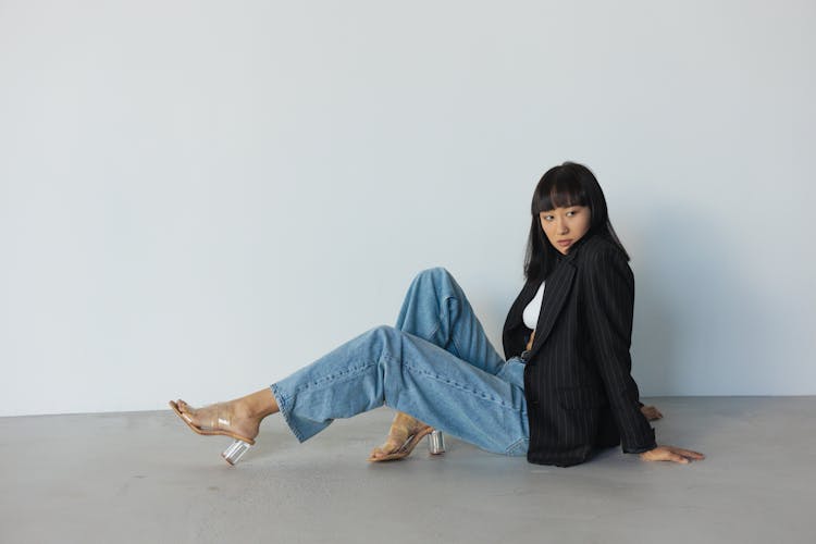 Woman In Dark Blue Blazer Posing On The Gray Floor 