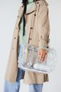 Woman in Brown Coat Holding Clear Plastic Pack