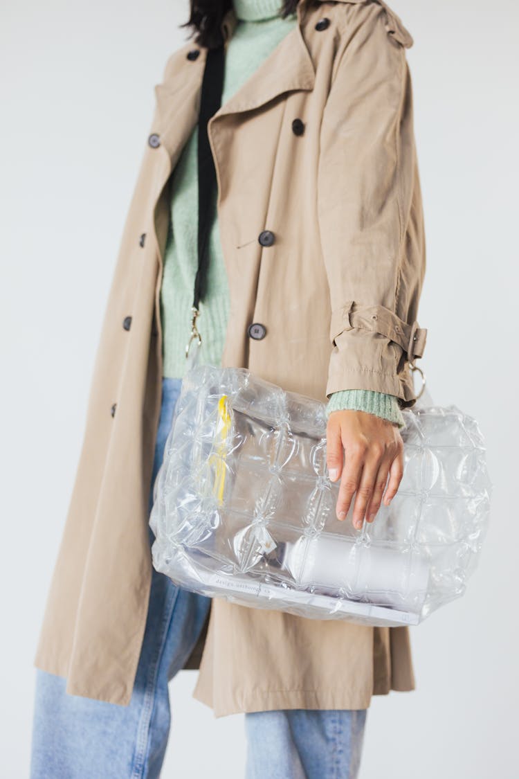 A Person In Brown Coat Carrying A Clear Plastic Bag