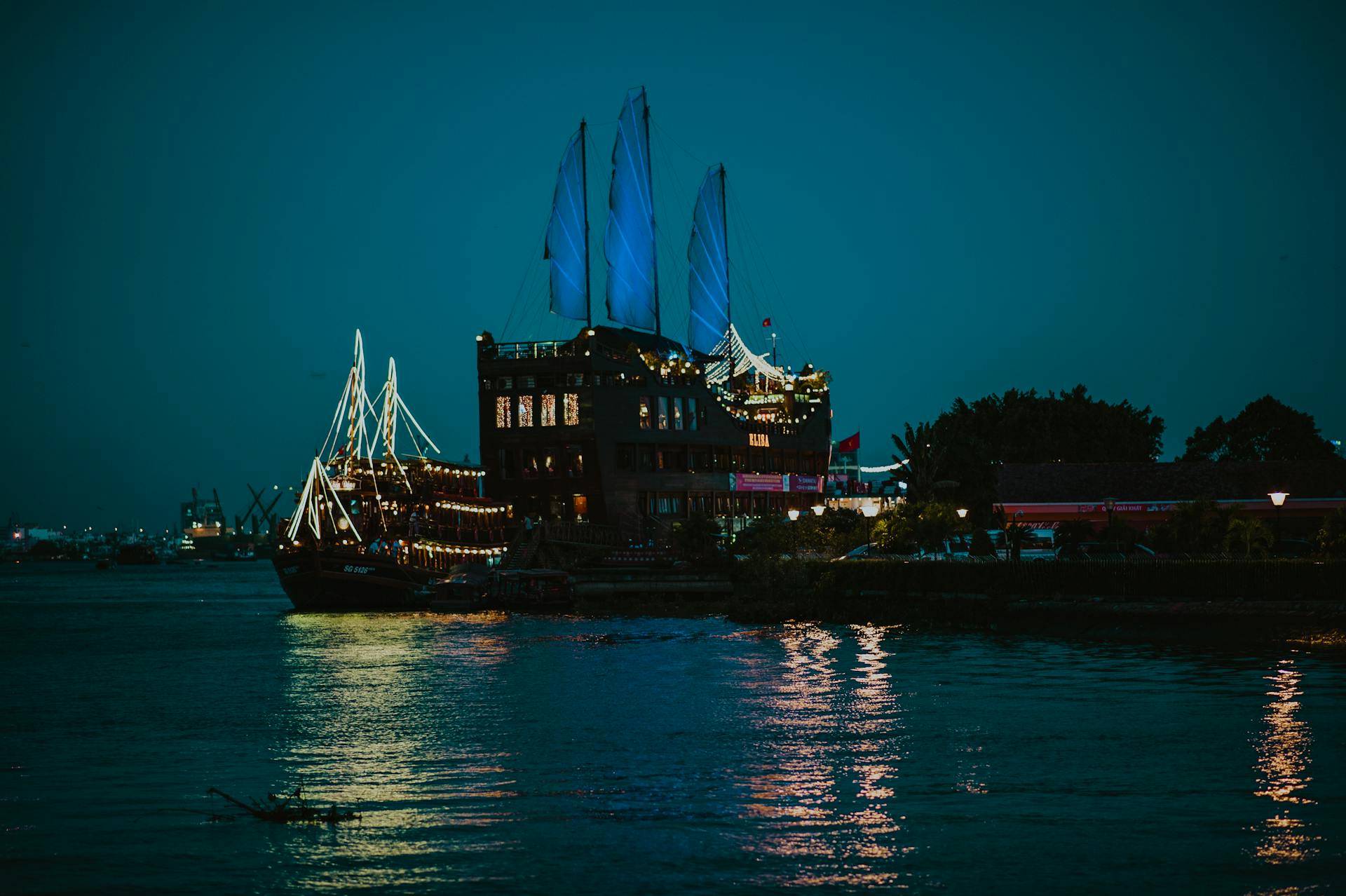A serene harbor at night with an illuminated ship reflecting on calm waters. Perfect for travel or maritime themes.