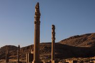 Majestic view of ancient columns at Persepolis, Iran, during sunset showcasing historical ruins.