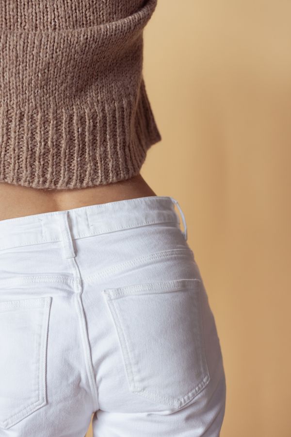 Woman in a saddle brown pullover with white jeans