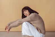 Woman in Gray Sweater and White Pants