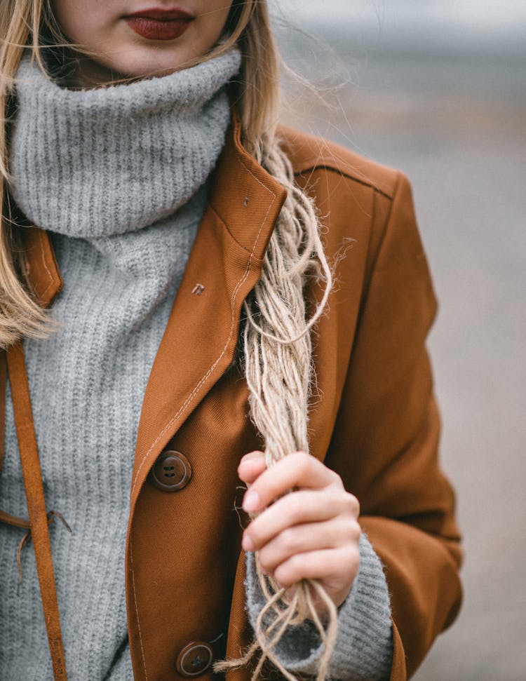 Woman In Stylish Brown Coat Holding Twine