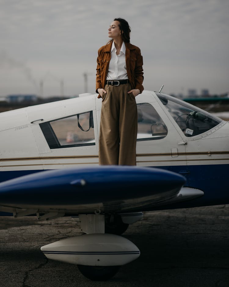 Elegant Dwoman Standing On Wing Of Plane