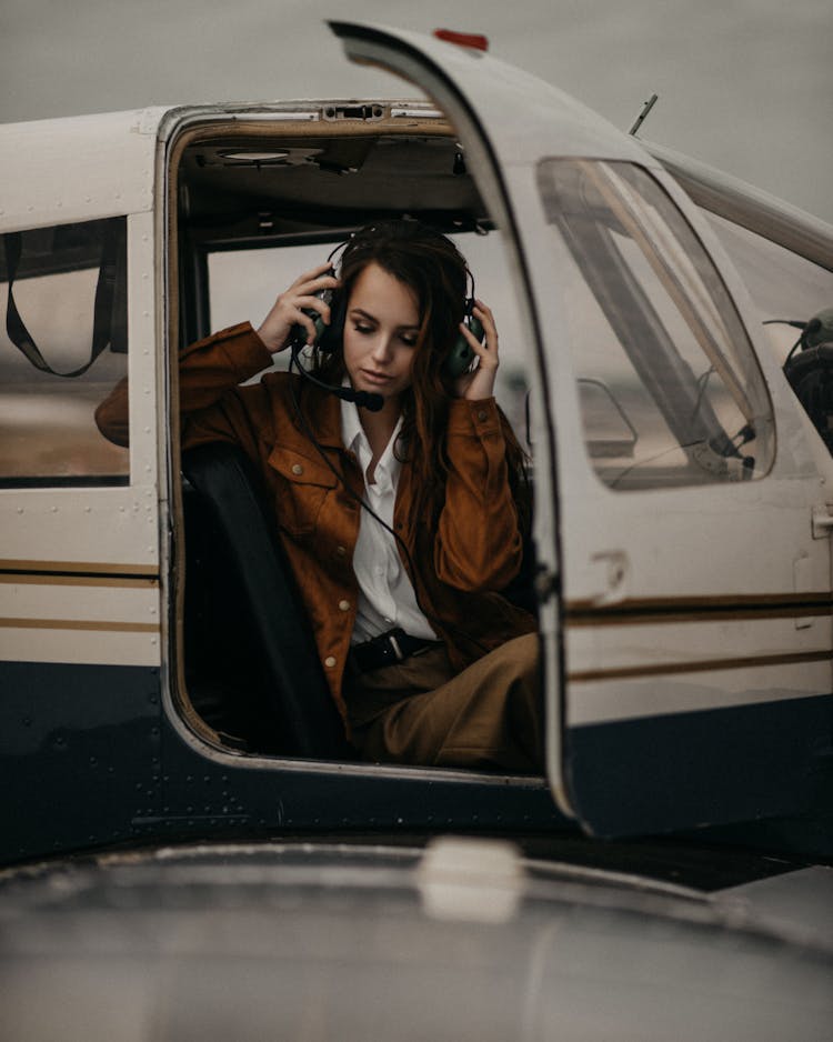 Stylish Woman In Headset Sitting In Plane