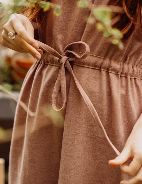 Unrecognizable woman near green branches