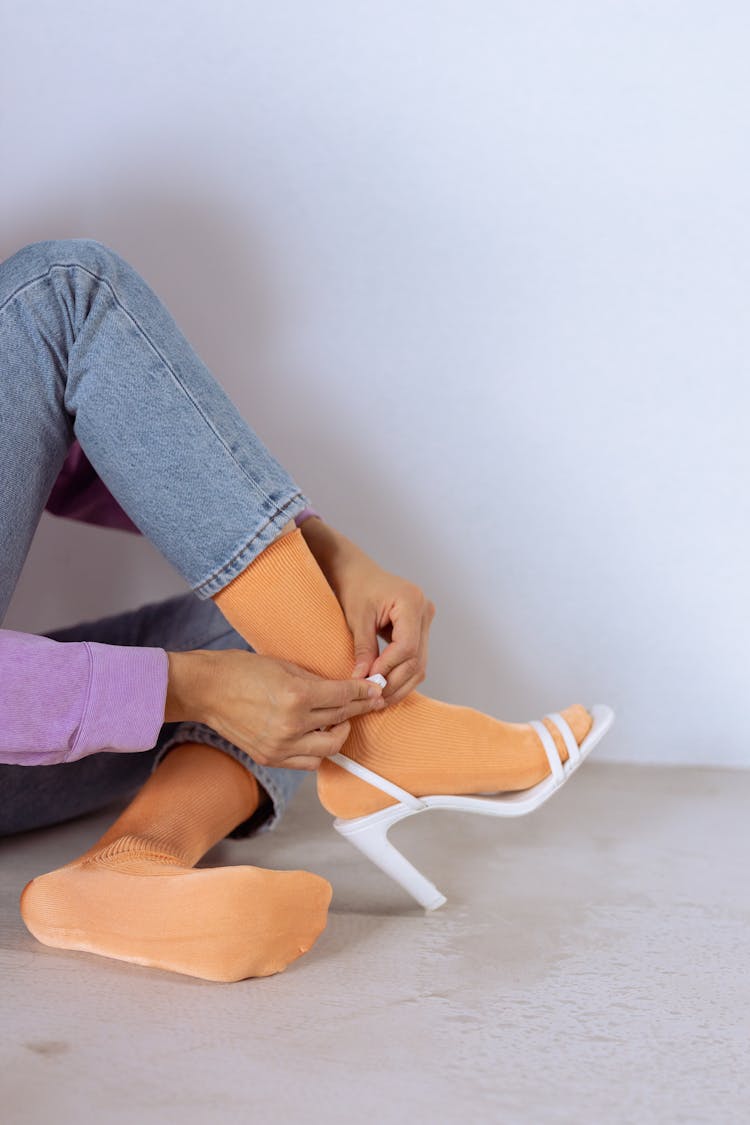 Woman Putting On A Shoe