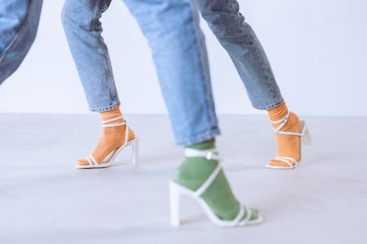 Stylish heeled sandals with colorful socks paired with denim jeans in a studio setting.