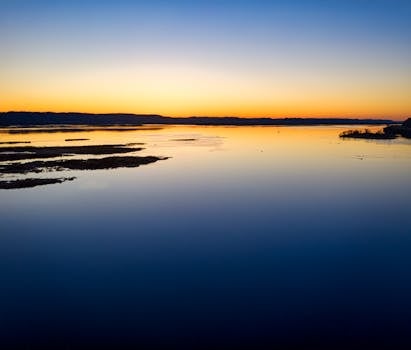 A serene sunrise over the Mississippi River in Minneiska, Minnesota, showcasing calm waters and a scenic landscape.