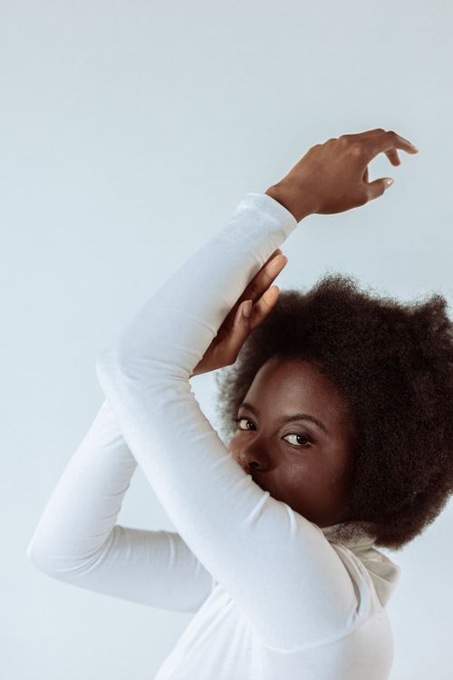 Free Elegant studio portrait of a fashionable black woman posing gracefully with afro hair. Stock Photo