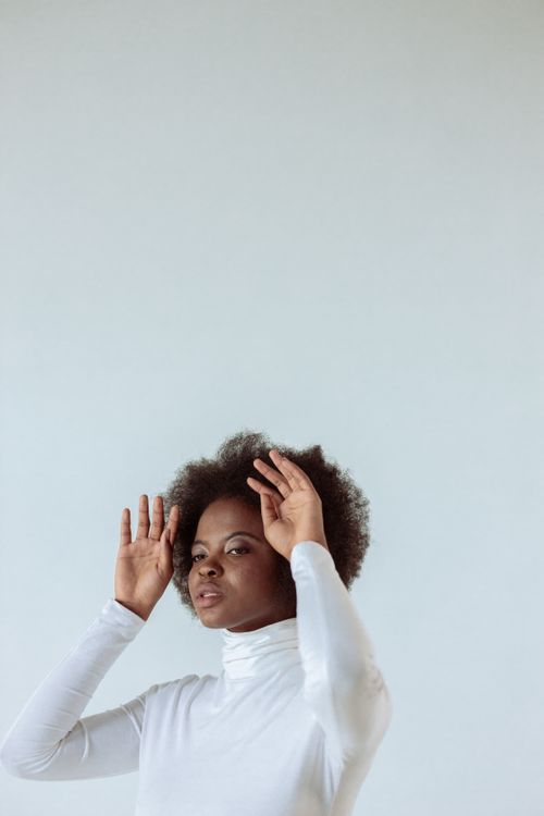Free Stylish portrait of a woman in a white turtleneck against a minimalist background. Stock Photo