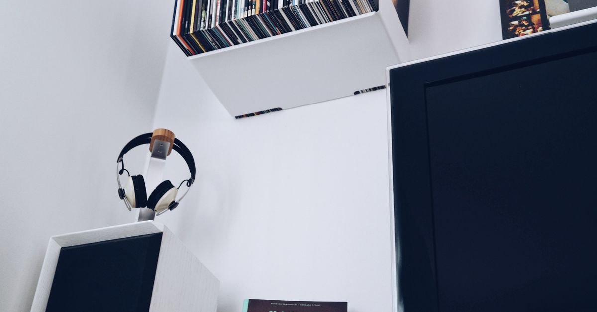 Modern turntable setup with headphones and a stack of colorful vinyl records on a shelf
