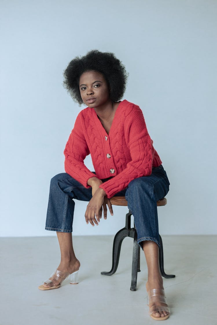 Woman In Pink Cardigan Sitting On A Stool