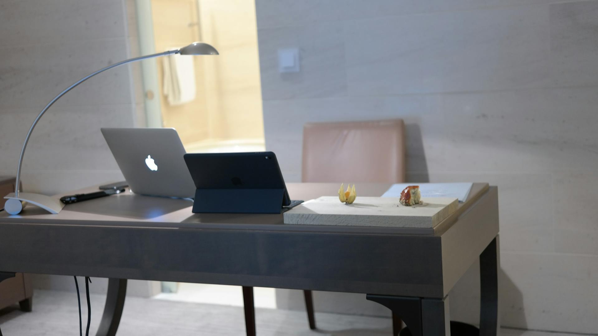 A clean and modern workspace with a laptop and tablet, emphasizing minimalist design.