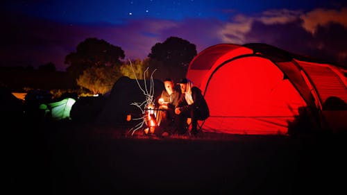 Mężczyzna I Kobieta Siedzą Przy Ognisku W Porze Nocnej