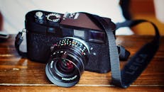 Black Dslr Camera on Top of Brown Wooden Table