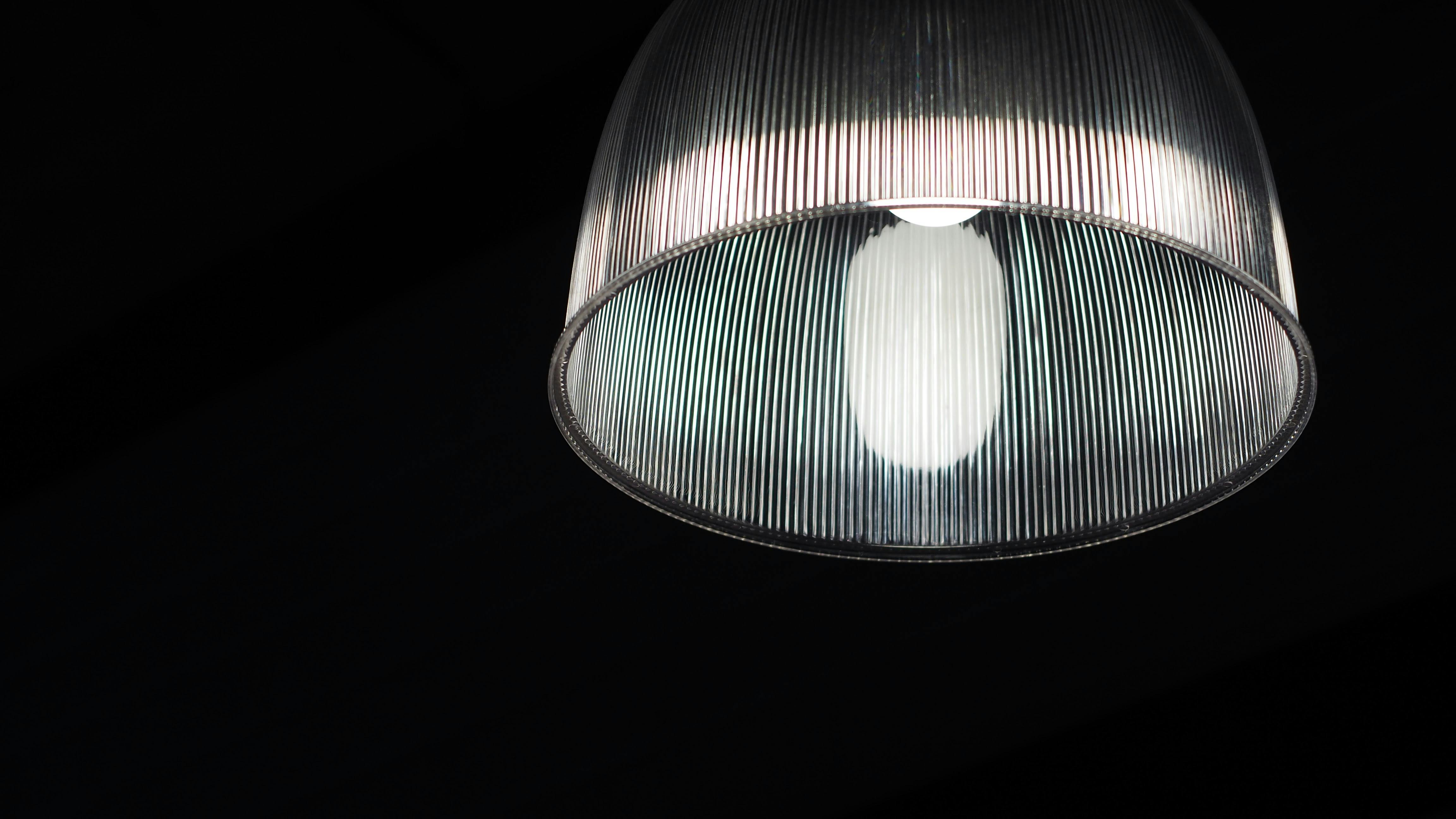 在黑暗背景下照亮的现代玻璃灯特写，展示其设计