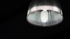 在黑暗背景下照亮的现代玻璃灯特写，展示其设计