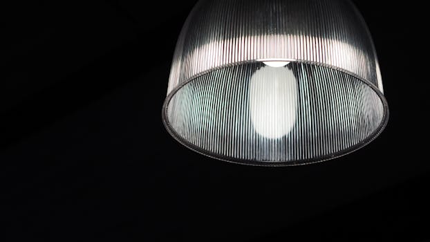 在黑暗背景下照亮的现代玻璃灯特写，展示其设计