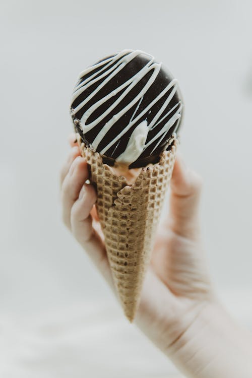 Free A Hand Holding an Ice Cream Cone Stock Photo