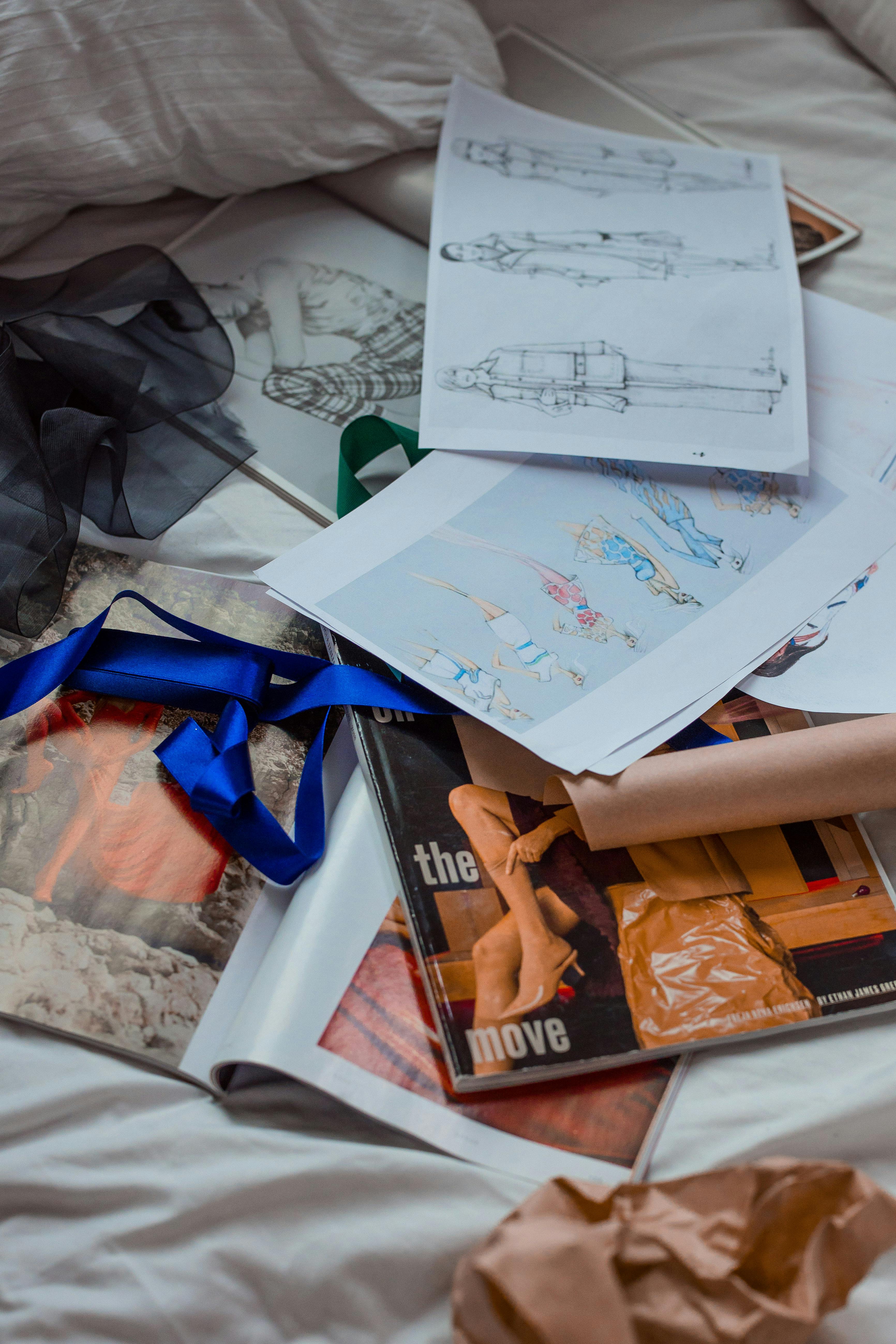 A collection of fashion sketches and materials scattered on a surface, perfect for creative inspiration.