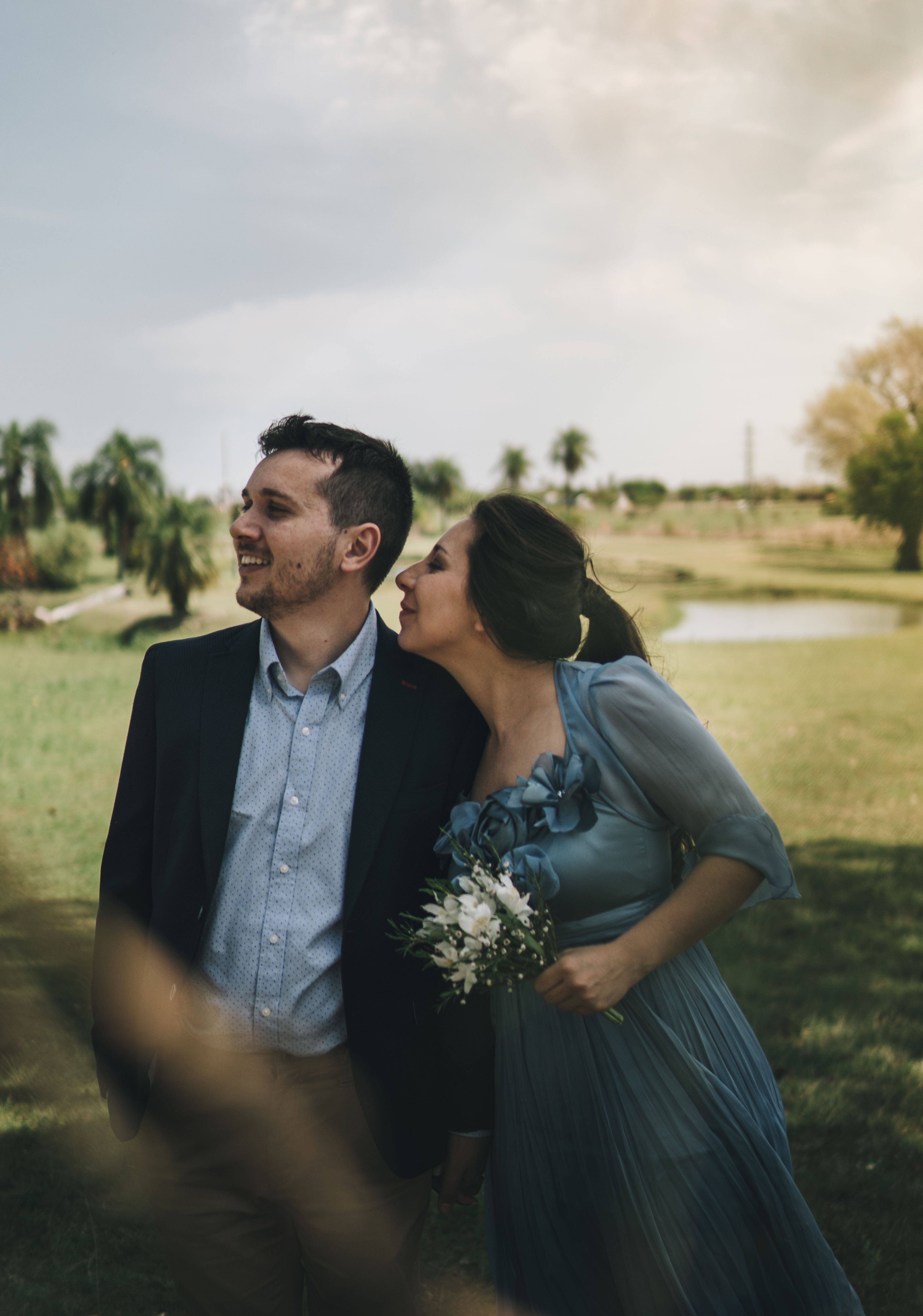 A Couple Holding Each Others Hand while Standing on a Grass Field ...