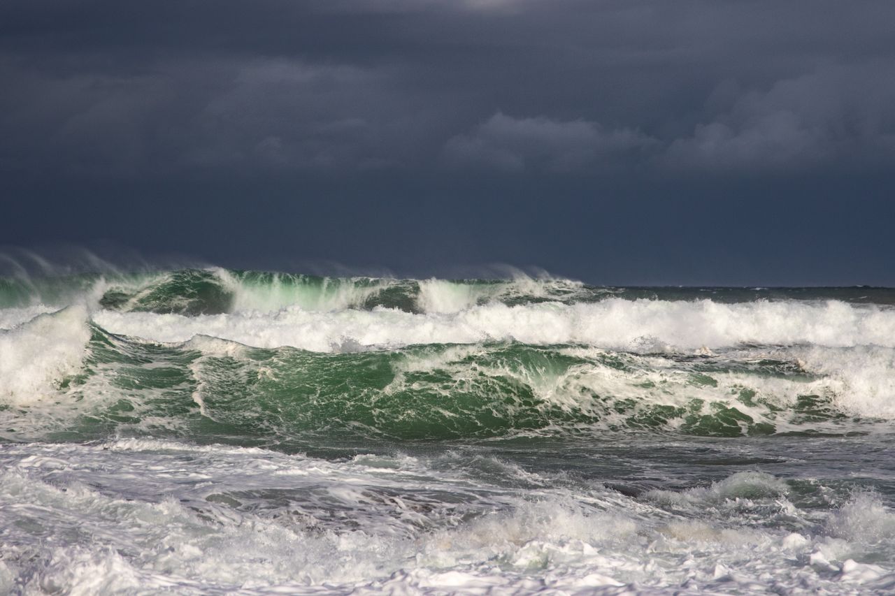 powerful ocean waves crash under dark stormy clouds capturing nature s